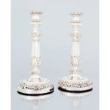 A pair of electroplate candlesticks each with fluted column with acanthus leaves between c-scroll,