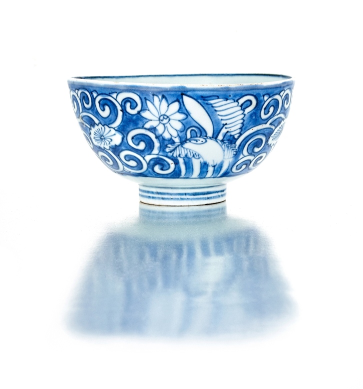 A Chinese provincial blue and white bowl, 18th century painted with flowers and scrolling foliage,