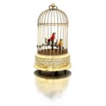 A Victorian singing bird automaton the red and yellow birds amongst wired fabric foliage, the