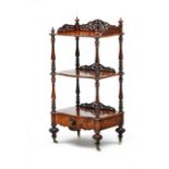 A Victorian walnut three-tiered whatnot the serpentine shaped top shelf with three-quarter pierced