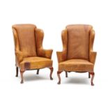 A pair of George II style brown leather and mahogany wing-back armchairs each with serpentine