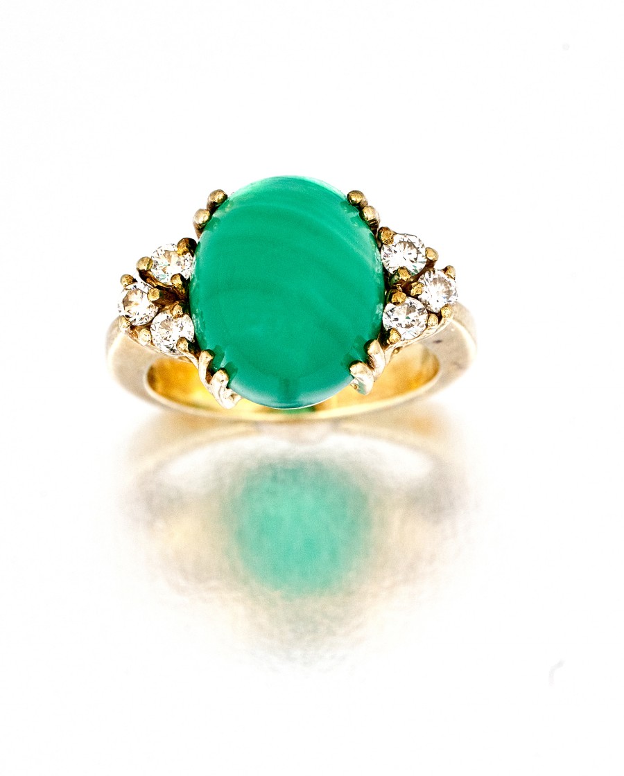Chrysoprase and diamond ring claw-set with a cabochon chrysoprase flanked by claw-set round
