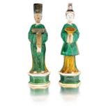 Two Chinese sancai-glazed pottery figures of attendants, Ming Dynasty each standing on a hexagonal