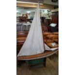 An old painted pond yacht, length of hull 122cm, on stand.  Condition Report: Condition overall is