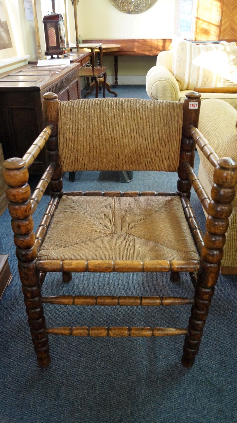 A 19th century beech, fruitwood and rush armchair, with bobbin and reel turnings. Condition