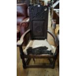 An antique carved oak caqueteuse type armchair, the back carved with initials 'D.B.', the rear of