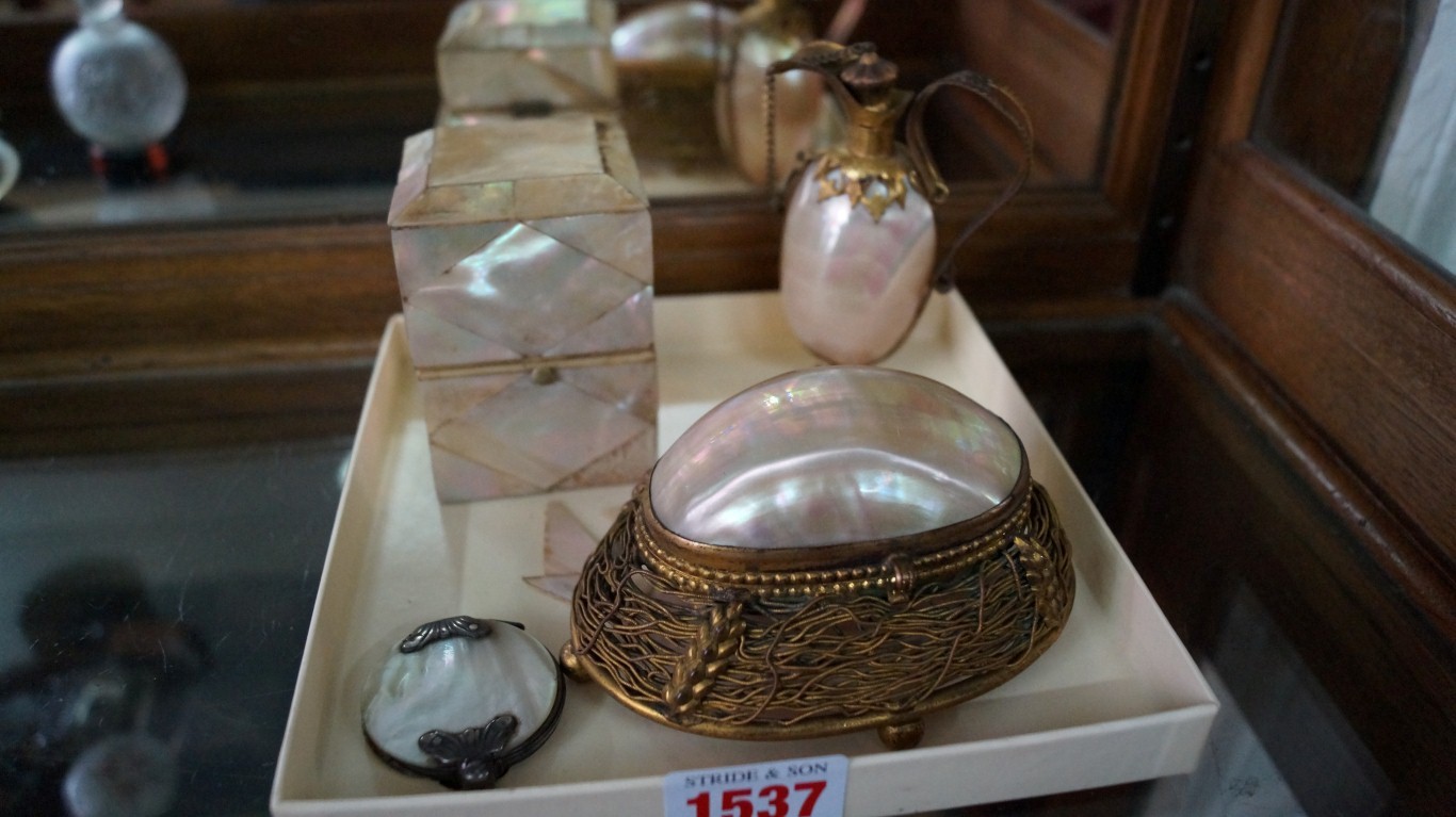 A small group of mother of pearl and shell items, to include: a cased clear glass inkwell; a brass