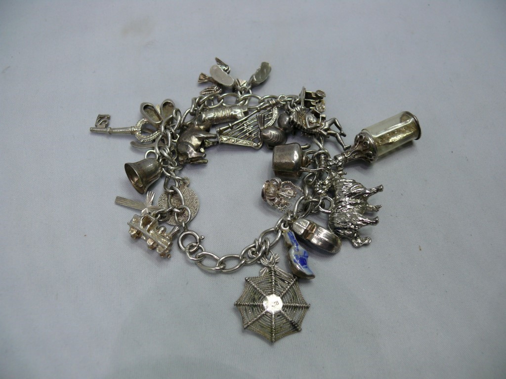 A silver charm bracelet, having twenty t
