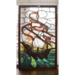 An antique stained and leaded glass panel of a galleon, 102 x 59cm.  Condition Report: Although