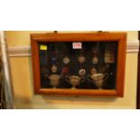 A framed display of 1930s football cups