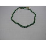 A jadeite bead necklace, having 14k yell