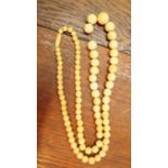 A graduated bone or ivory bead necklace,