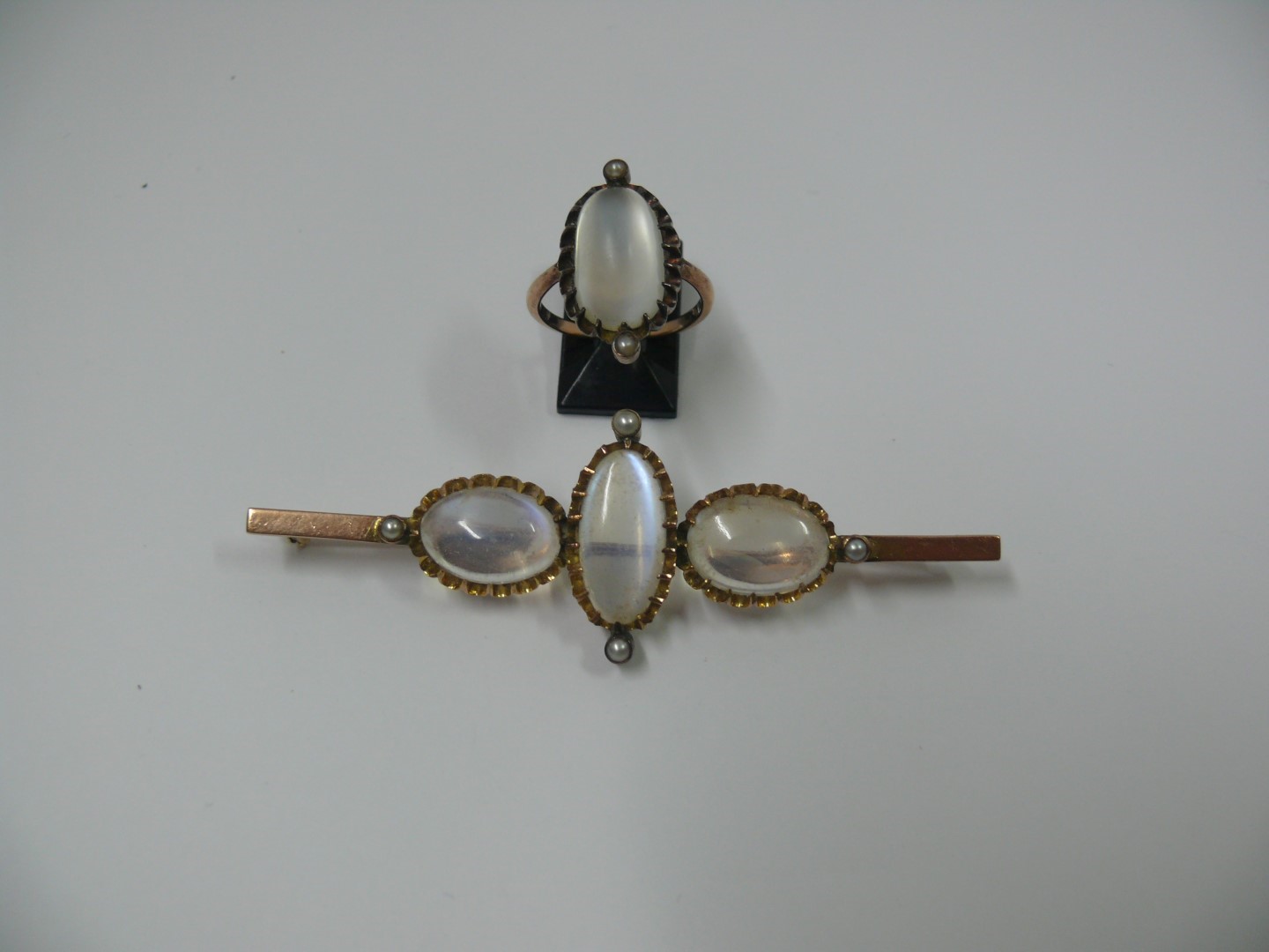 A 9ct gold bar brooch set three oval moo