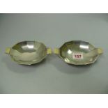 A pair of silver two handled bonbon dishes, by Walker & Hall, Birmingham 1935, the handles inset