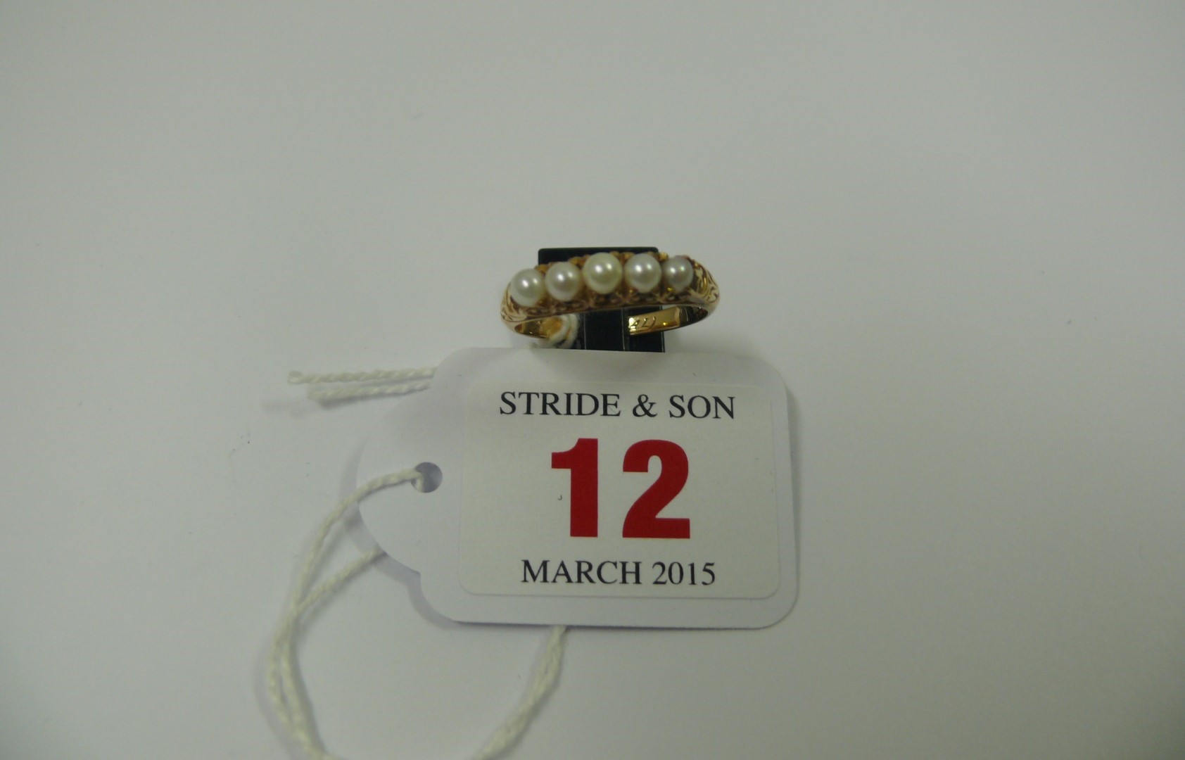 An unmarked gold ring set five inline pe