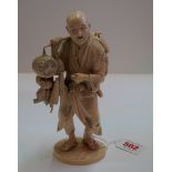 A Japanese carved ivory okimono figure of a street vendor, Meiji period, signature tablet to base,