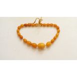 An amber and silver gilt necklace, with nine graduated spherical beads, largest 19mm diameter,