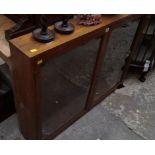 An oak hanging bookcase, with a pair of glazed doors, 114cm wide.