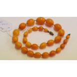 A 'butterscotch' amber bead necklace, of twenty-nine graduated oval beads, 45cm long, 27.8g.