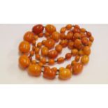 A 'butterscotch' amber graduated bead necklace, of sixty two oval beads, 60g.