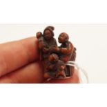 A Japanese carved wood netsuke, 19th century, depicting two adults and two children, signed, 4cm