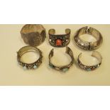 Six Eastern cuff bangles, four set hard stones.