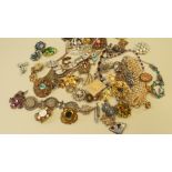 A quantity of costume jewellery to include necklaces and brooches, some set coloured stones.