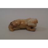 A Chinese carved celadon and mottled russet jadeite qilin, seated on its haunches, 10cm long.