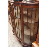 A 1920s mahogany serpentine fronted display cabinet, 108cm wide.