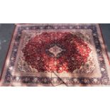 A Wilton style maroon carpet having central medallion, blue bordered, with allover pattern,