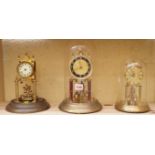 Three anniversary clocks, to include: a Kundo example, two with glass domes.