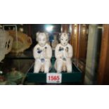 Two Cizhou ware seated figures, probably Ming, each holding a lotus, 11cm high.