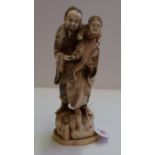 A Japanese carved ivory okimono of a man and child, Meiji period, signed to underside, 23.5cm high.