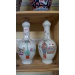 A pair of Chinese famille rose garlic head vases, Qianlong seal marks, each painted with vases of
