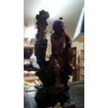 A Japanese carved wood figure of a man, of two-tone colour, standing and appearing to pick his nose,