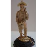 A Japanese sectional carved ivory okimono of a gardener, Meiji period, on wood base, total height
