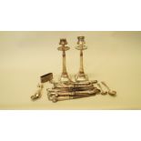 A pair of silver candlesticks; together with eleven silver handled pistol grip knives and six forks;