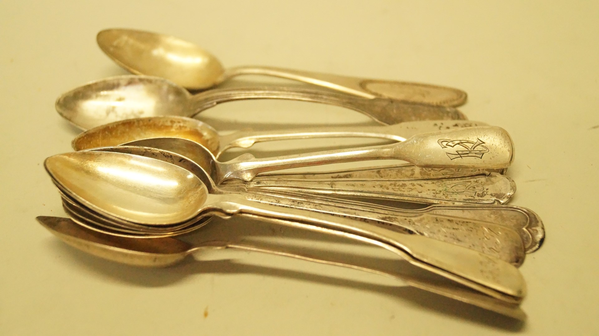 Ten various continental .800 teaspoons and one plated teaspoon.