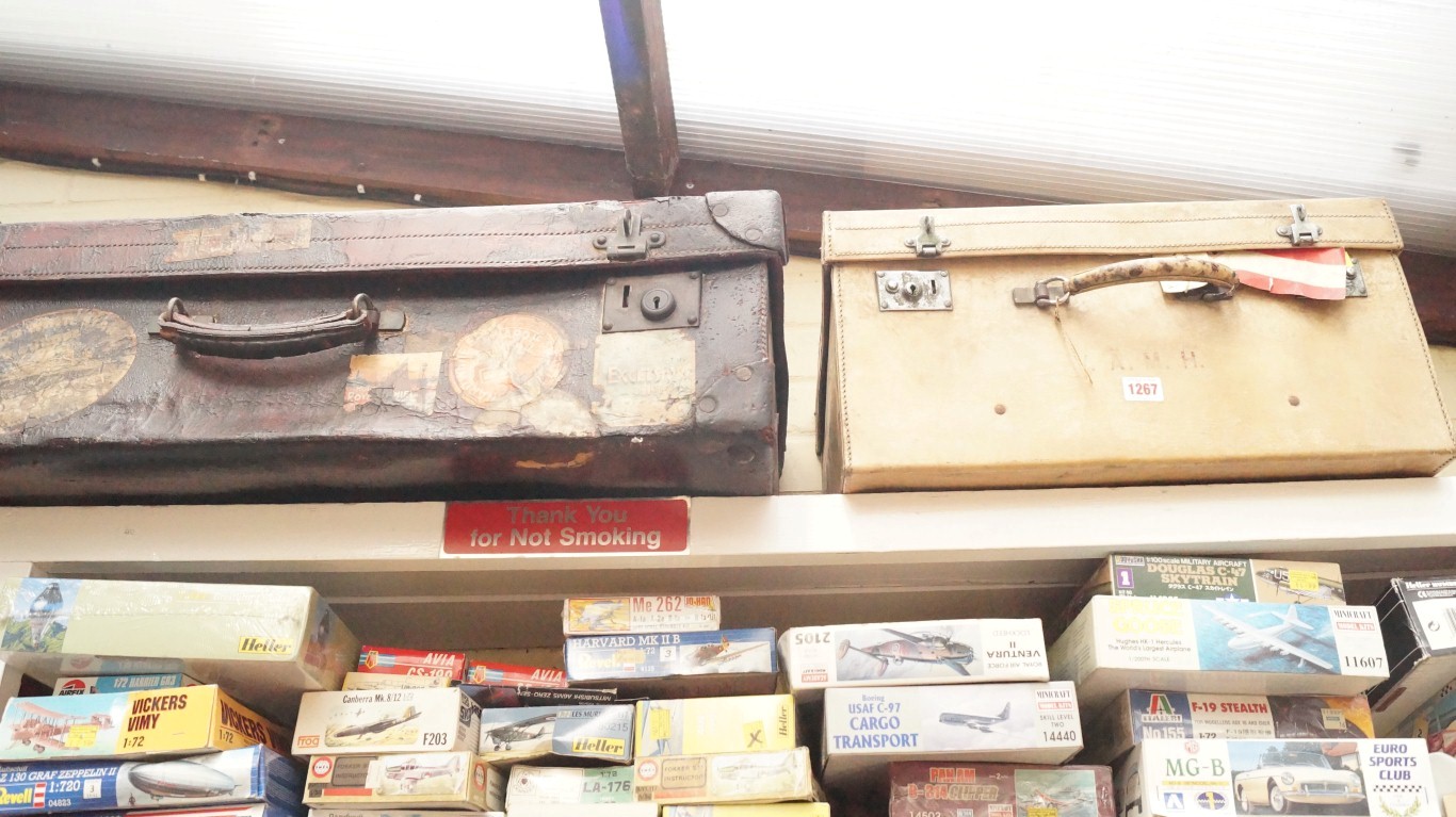 A vintage vellum suitcase; together with another old leather suitcase.