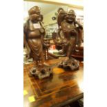 A pair of oriental carved hardwood figures, 36.5cm high.