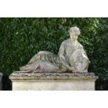 Garden Sculpture: A carved Portland stone figure of a reclining classical maiden holding an armorial