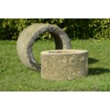 Two carved cylindrical stone planters     the larger 40cm.; 16ins high by 63cm.; 25ins diameter