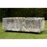 A large carved limestone trough  76cm.; 30ins high by 231cm.; 91ins long by 110cm.; 43ins deep