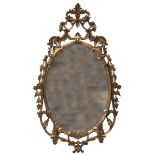 An oval carved and gilded wood Mirror  in Rococo style with age gilt style 120cm.; 47ins high by