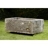 A rectangular carved stone trough  54cm.; 21ins high by 145cm.; 57ins long by 89cm.; 35ins deep