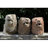 A pair of carved Vosges stone lions head architectural fittings  possibly 17th century the larger