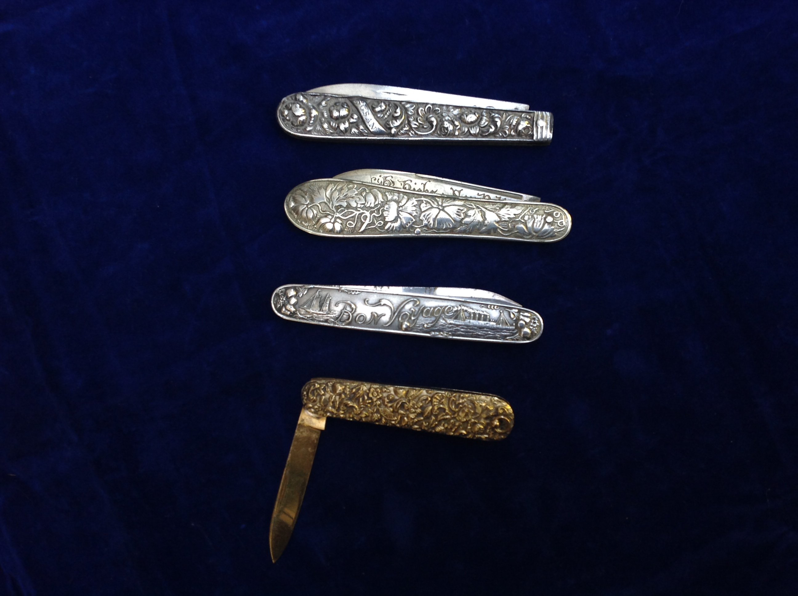 THREE 19TH CENTURY SILVER PENKNIVES  With repoussé handles, along with a gilt metal penknife.