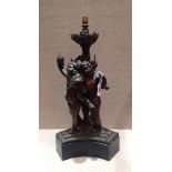 A 19TH CENTURY BRONZE LAMP BASE Cast as three cavorting cherubs feasting on grapes.