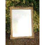 IN THE MANNER OF WILLIAM KENT A 19th Century gilt framed mirror, with ribbon and bow cresting. (57cm