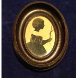 A 19TH CENTURY OVAL PAINTING ON PAPER Silhouette of a young girl holding a riding crop, contained in